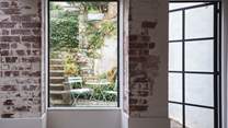 There's a handy door from the kitchen out to the tucked away courtyard garden with bistro table and chairs, with stairs leading up to the main garden