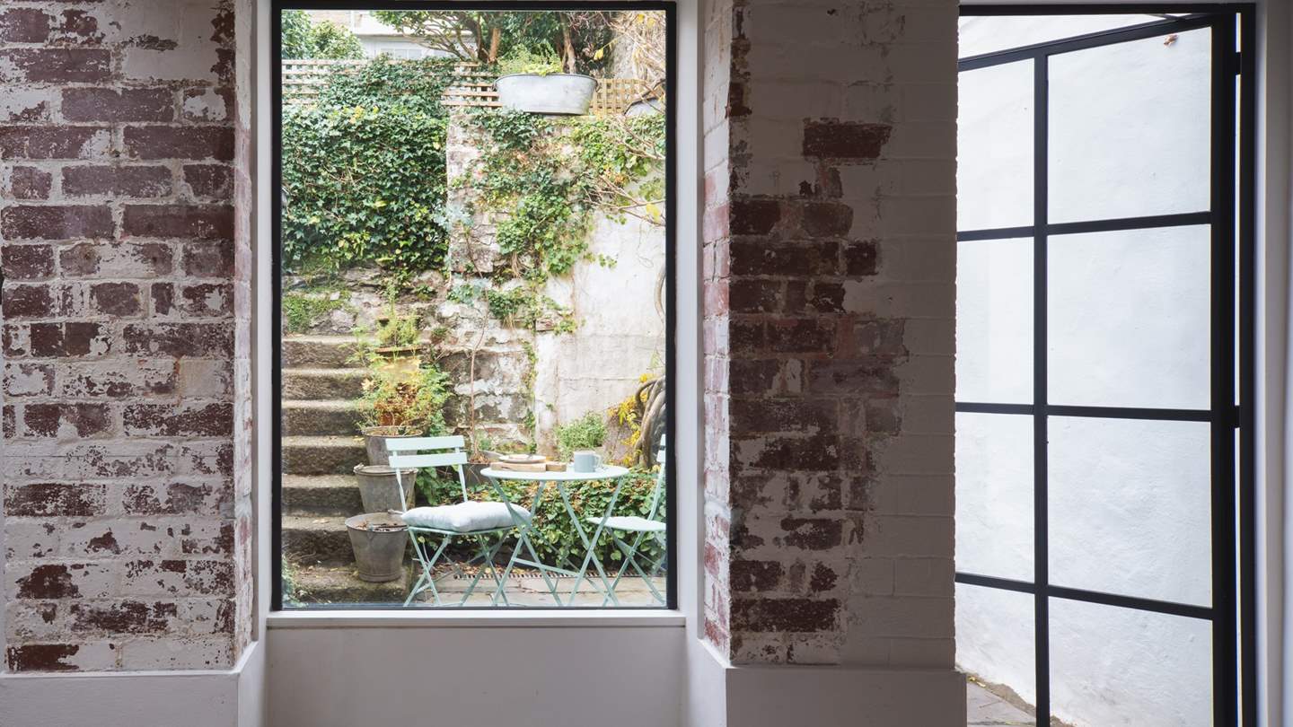 There's a handy door from the kitchen out to the tucked away courtyard garden with bistro table and chairs, with stairs leading up to the main garden