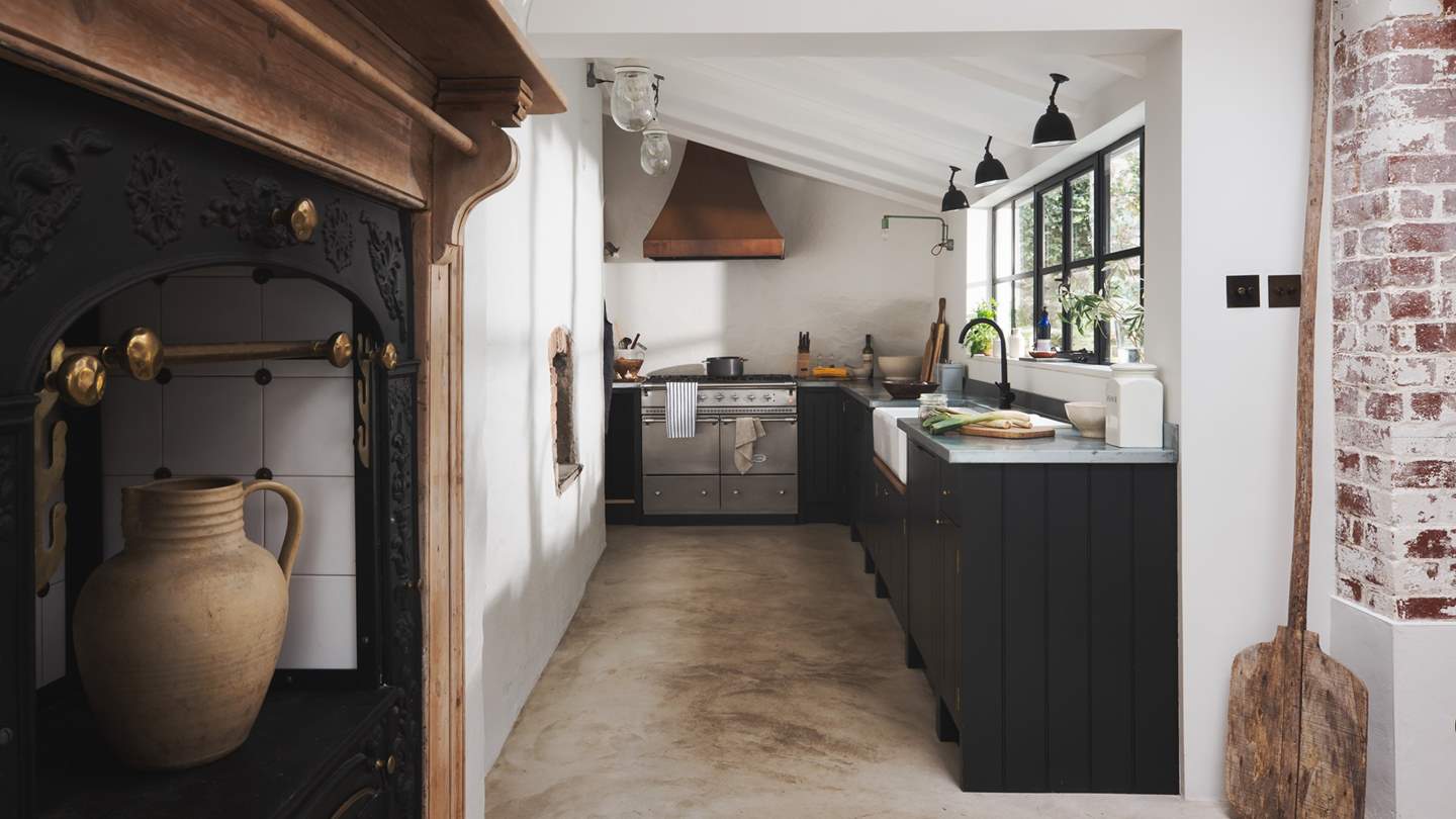 The incredible kitchen, with a sideways glimpse at the original Cornish Range and beyond that the original bread oven