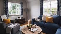 The charming sitting room offers plenty of seating, perfect for families and friends to gather