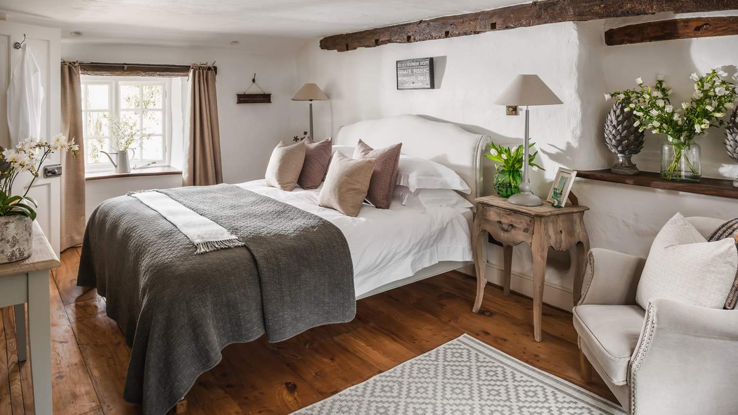 For blissful repose, the stunning master bedroom in Apple Blossom House is a picture of serenity with white-washed hues and garden views