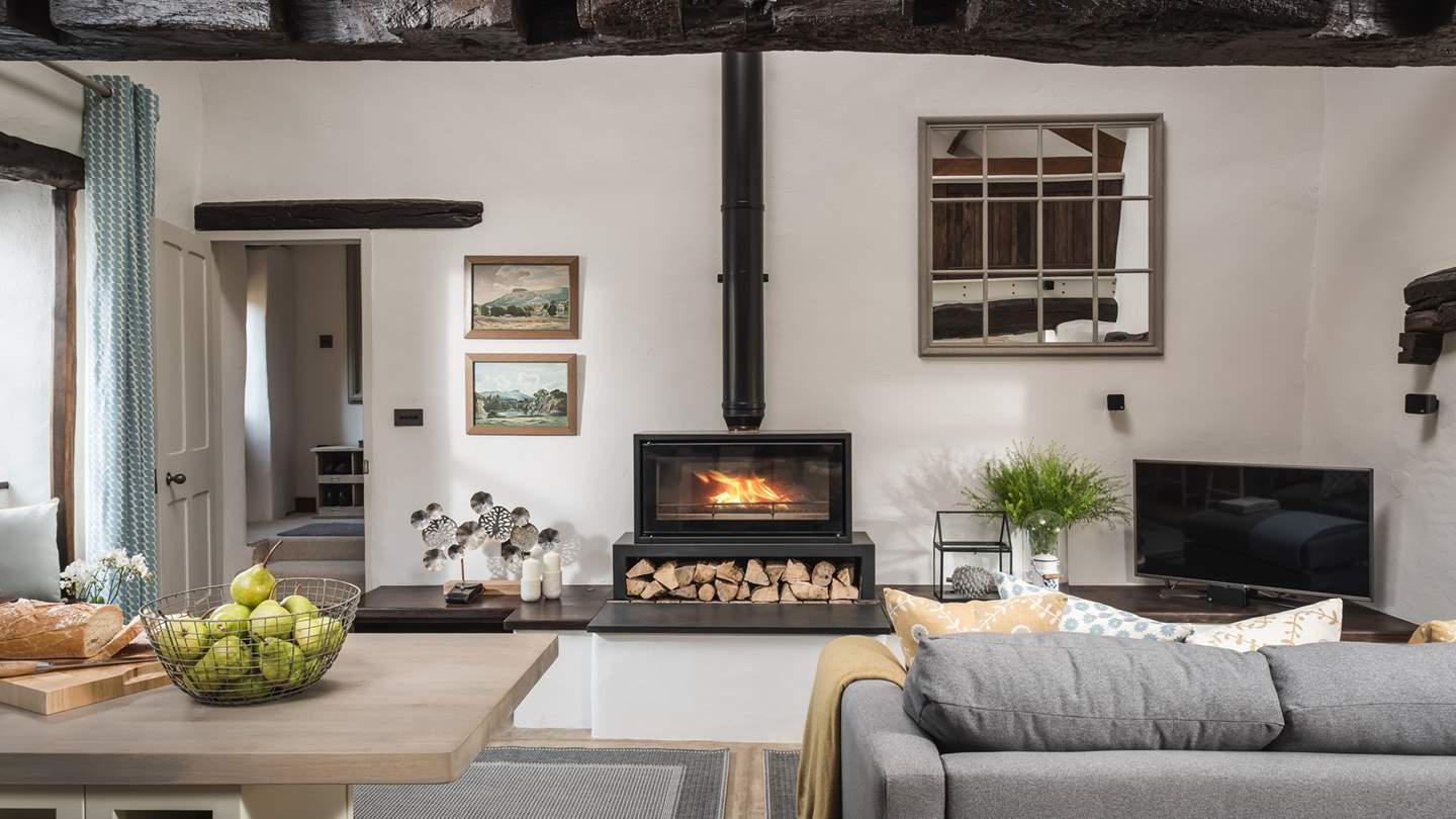 An idyllic romantic retreat or quiet haven, it features a comfortable sofa, ottoman and armchair in grey, each topped with cloud-soft cushions and blankets