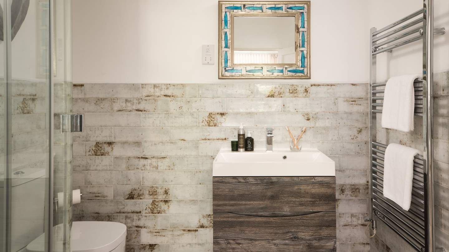 We love the travertine tiles of this en suite shower room