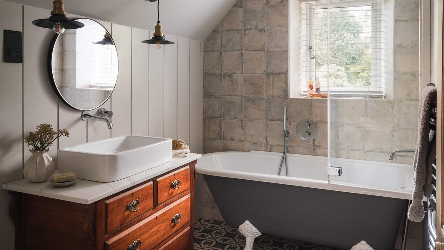 Slip softly into the romantic roll-top bathtub and relish self-care rituals in the delightful en suite bathroom, complete with an overhead shower