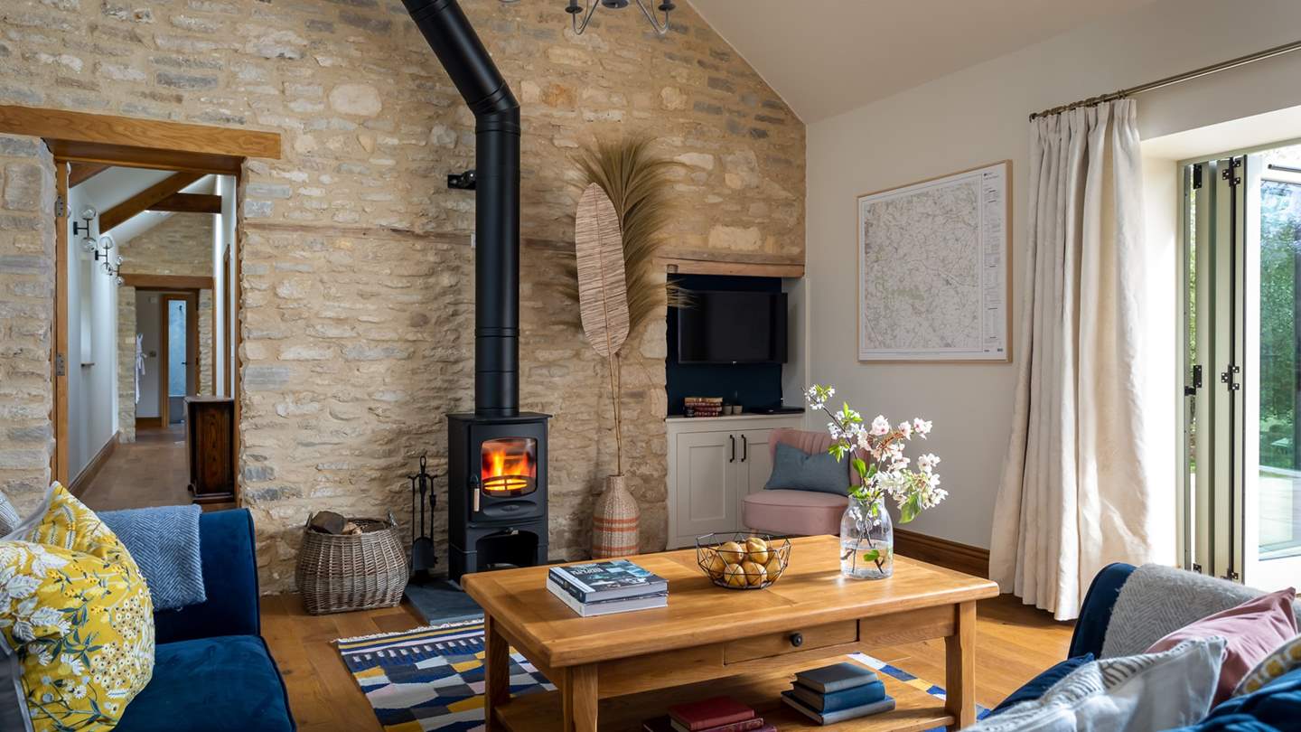 The stunning open plan living area, with vaulted ceiling and exposed Cotswold stone wall