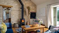 The stunning open plan living area, with vaulted ceiling and exposed Cotswold stone wall
