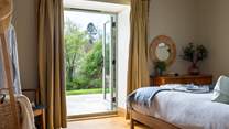 Double doors lead out from this room into the garden - enjoy a pretty view from the comfort of bed!
