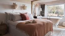 The oh-so-dreamy double bed is swathed in luxurious linens, guaranteeing a blissful nights' sleep
