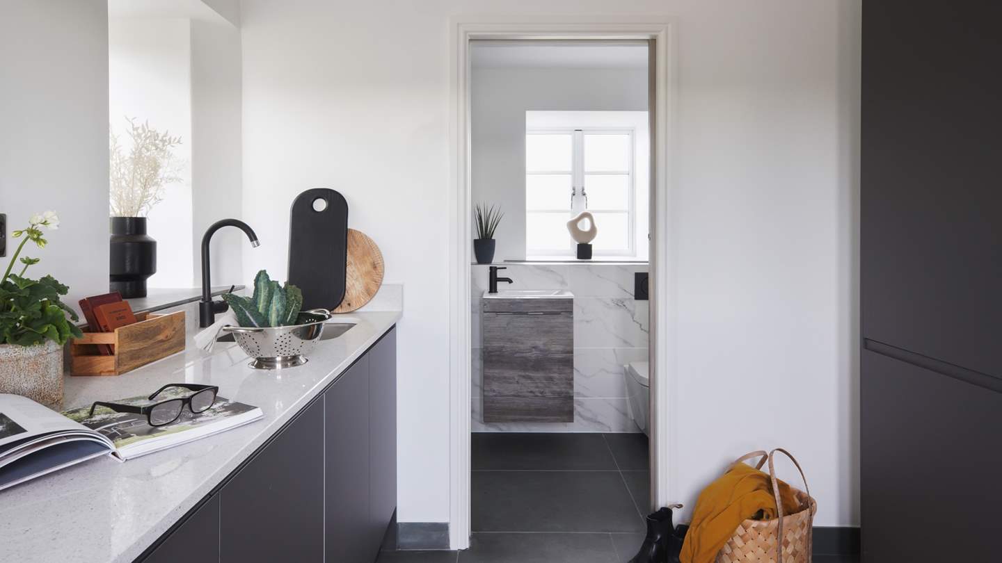 Off of the kitchen lies the downstairs cloakroom with shower