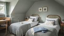 The twin bedroom is simply charming with eye-catching cane headboards