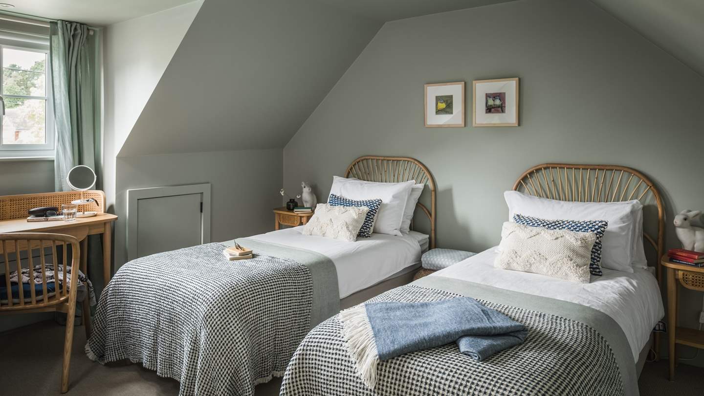 The twin bedroom is simply charming with eye-catching cane headboards