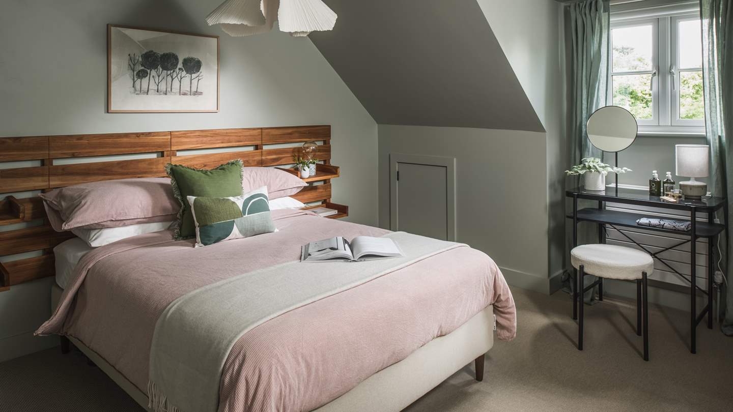 The second bedroom is soothing in pale pink and sage hues 
