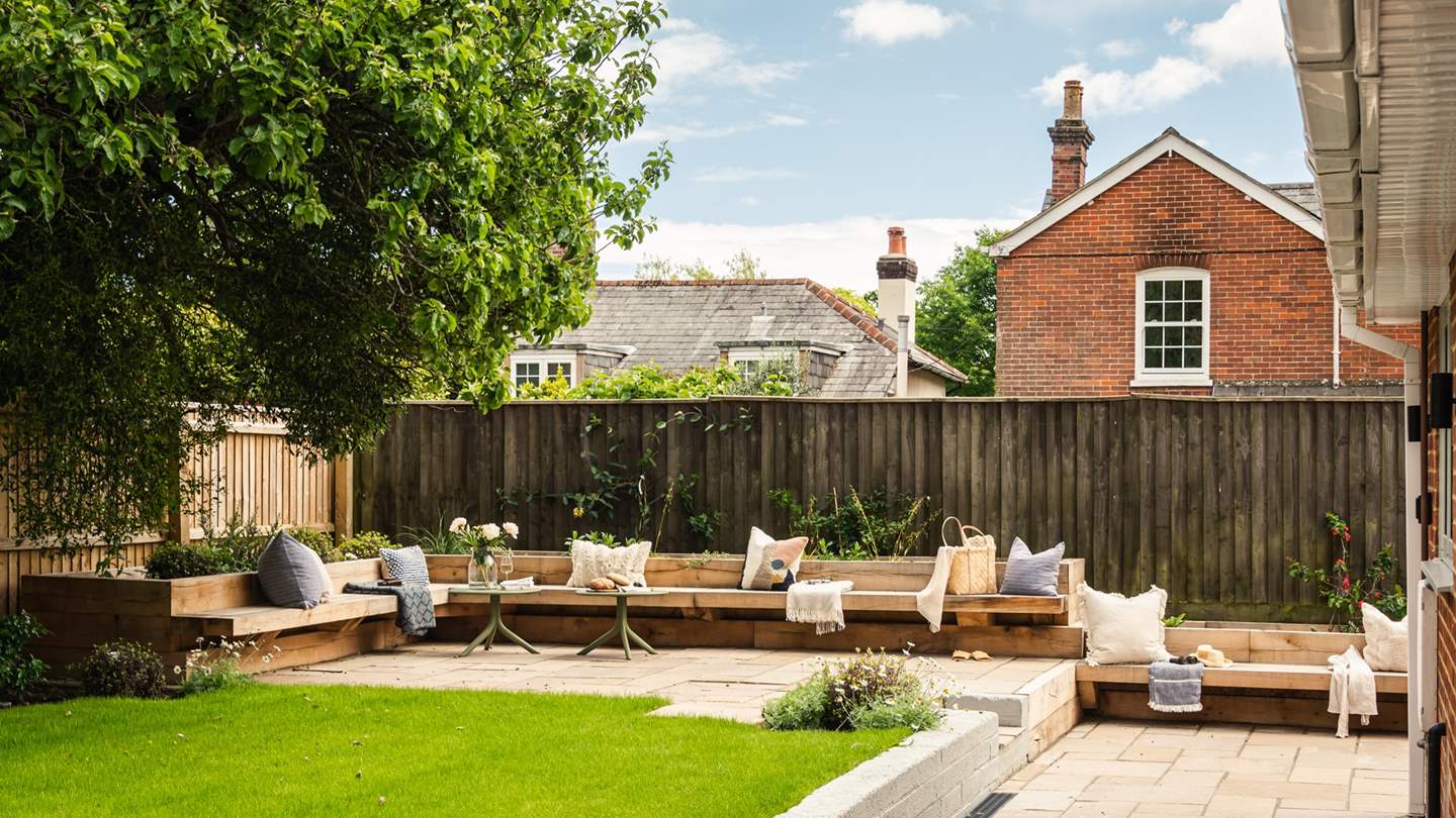 Step outside to uncover the garden, immaculately kept with fitted oak benches and accompanying coffee tables