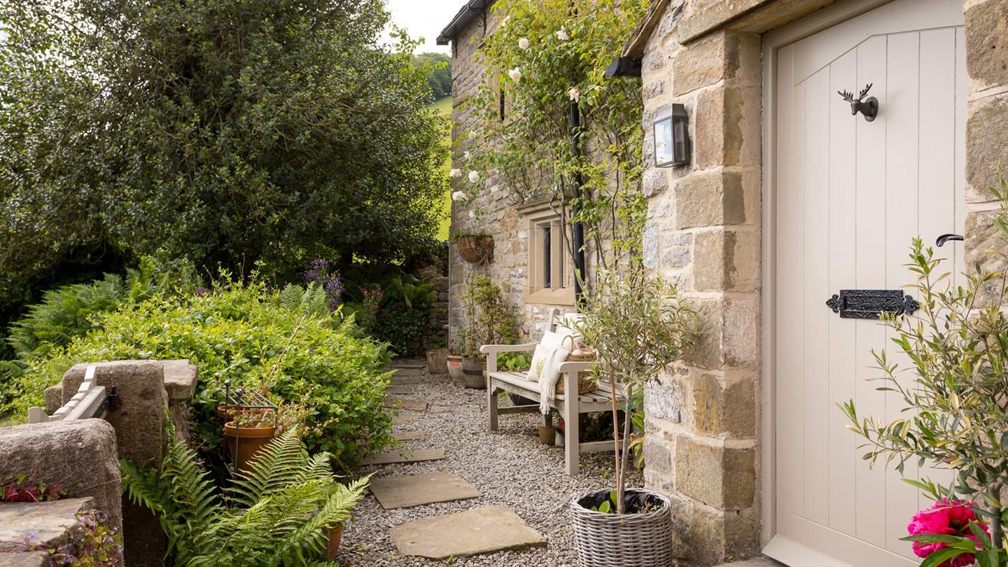 The front garden, strewn with climbing roses, is a sunny spot with spectacular views