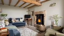 The pretty sitting room with exposed beams and wood burner is an idyllic retreat at the end of a busy day exploring