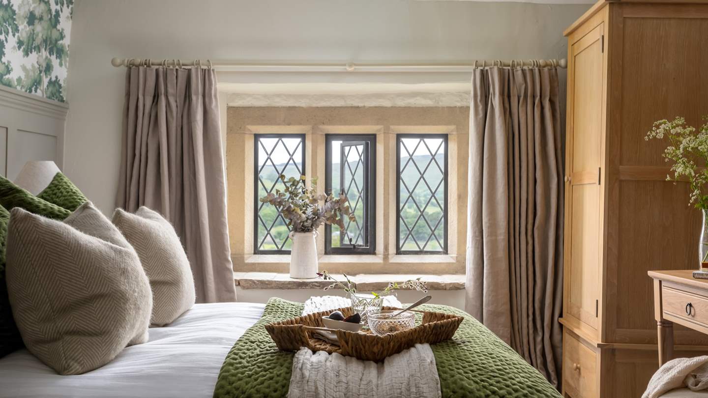 The stunning master bedroom, with king-sized bed and blissful views over the rolling hills