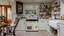 Steps lead up to the quintessentially charming English kitchen, where Kilner jars and collectables line the walls