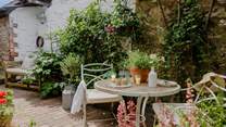 A courtyard garden enchants for dreamy alfresco dining beneath a leafy arbour