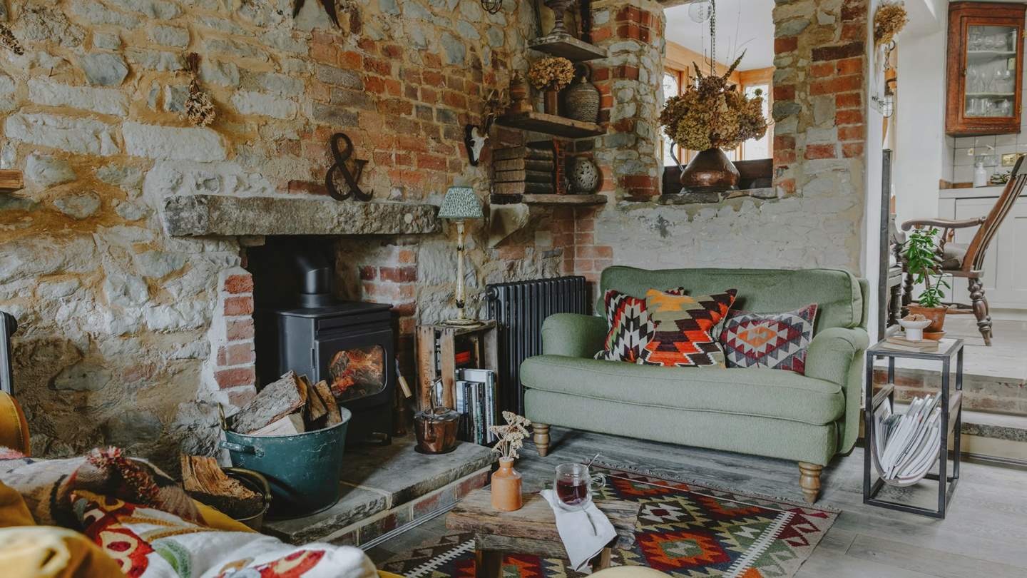 The wonderful sitting area, complete with a wood burner, comfortable sofa and snug loveseat is perfect for cosy evenings in