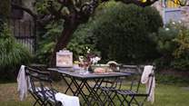 The dining table is perfect for alfresco meals under the roses 