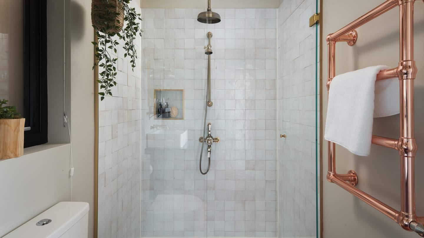 The jaw-dropping bathroom, where you'll find a large walk-in shower, elegant Moroccan tiles, and a beautiful copper rail for keeping towels warm and fluffy 
