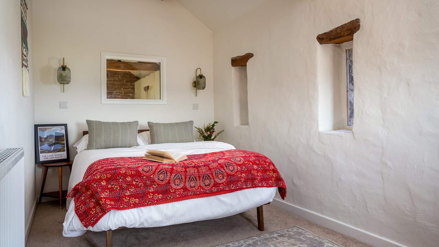 This charming double bed is dressed in luxurious linens and throws, perfect for restful slumbers 