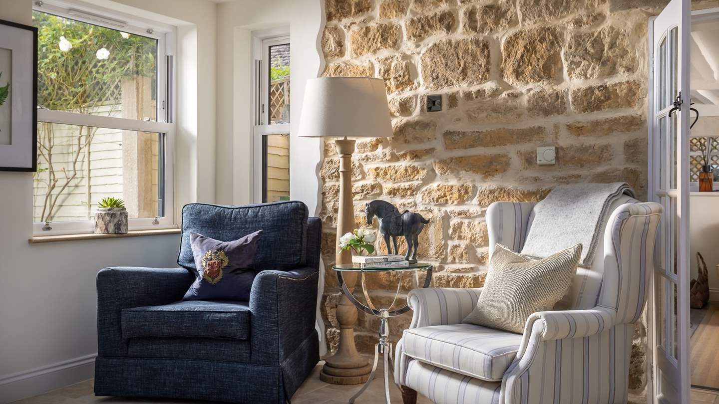 This charming reading nook is complete with an exposed Cotswold stone feature wall