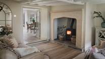 A striking feature fireplace set in golden Cotswold stone beckons for toasty relaxation 