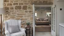 With an exposed Cotswold stone feature wall, where two opulent armchairs rest - a blissful nook for settling down with a book
