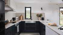 The chic kitchen with stylish black cabinets has all you should need during your stay... 