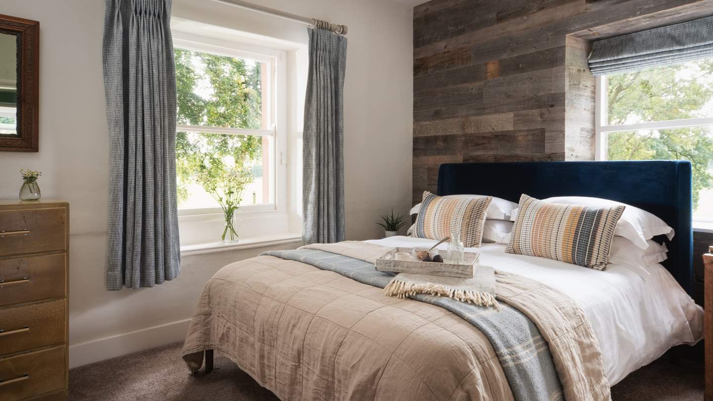 A king-sized bed awaits in the beautiful bedroom, swathed in soft, luxurious linens 