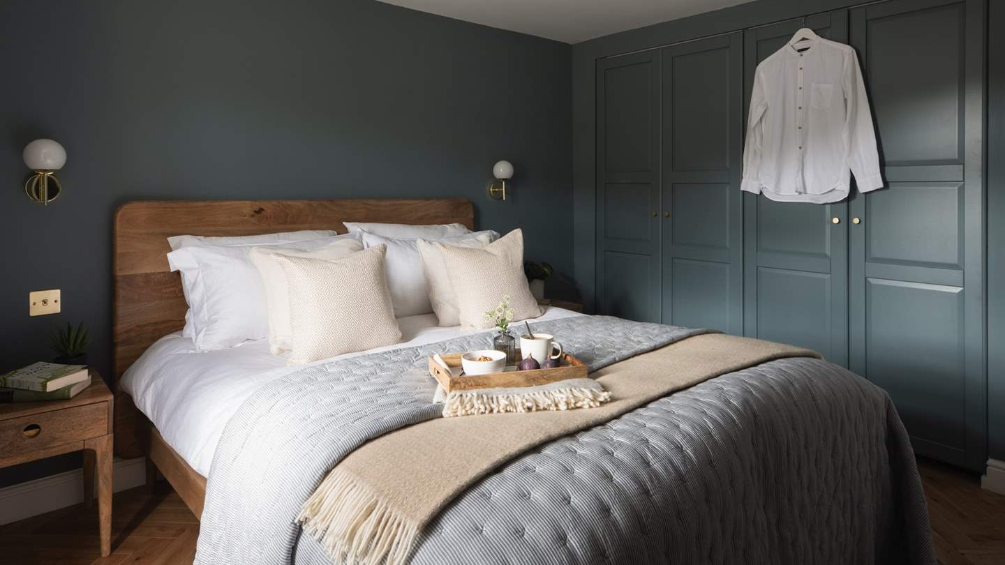 Dressed in rich blues and grey tones, the sumptuous master bedroom promises a decadent sleep setting