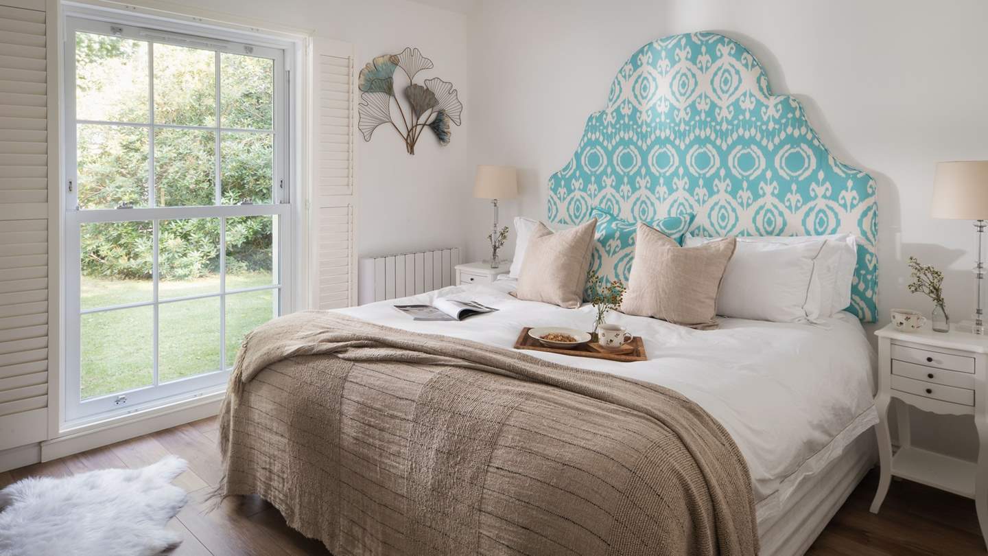 Uncover the elegant master bedroom boasting gorgeously verdant garden views...