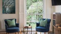 Settle on an elegant occasional chair with your favourite tipple in hand, admiring the luscious leafy vistas through the large sash windows