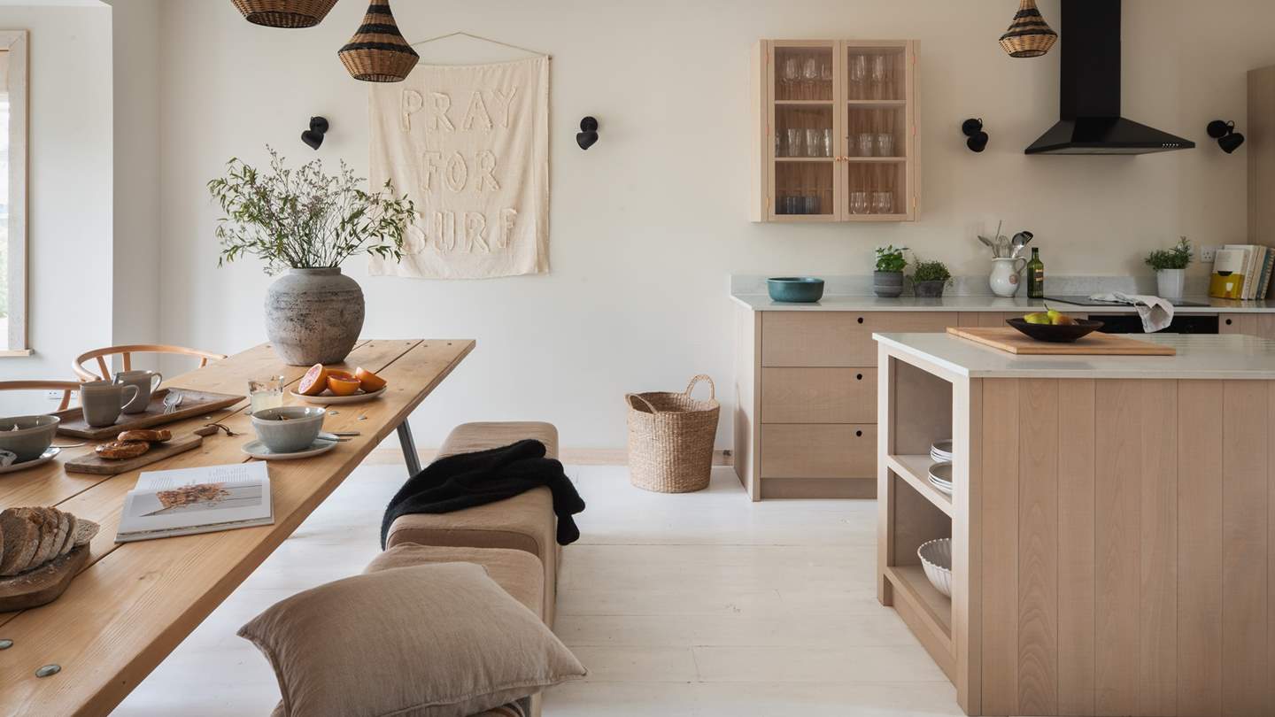 We just adore the lavish open-plan kitchen and dining space, where white-washed floors harmonise with neutral tones and natural textiles