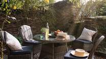 A wicker dining table for four awaits for delicious meals alfresco