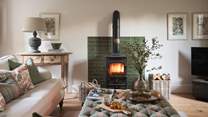 Taking centre stage in front of glossy emerald feature tiling resides the handsome wood burning stove
