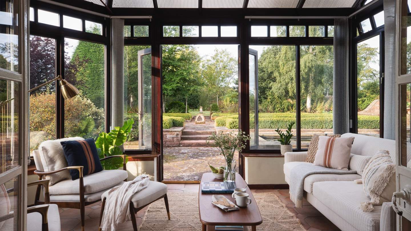 Through a set of timeless French doors lies the bright and airy conservatory that enjoys sweeping views over the picture-perfect garden