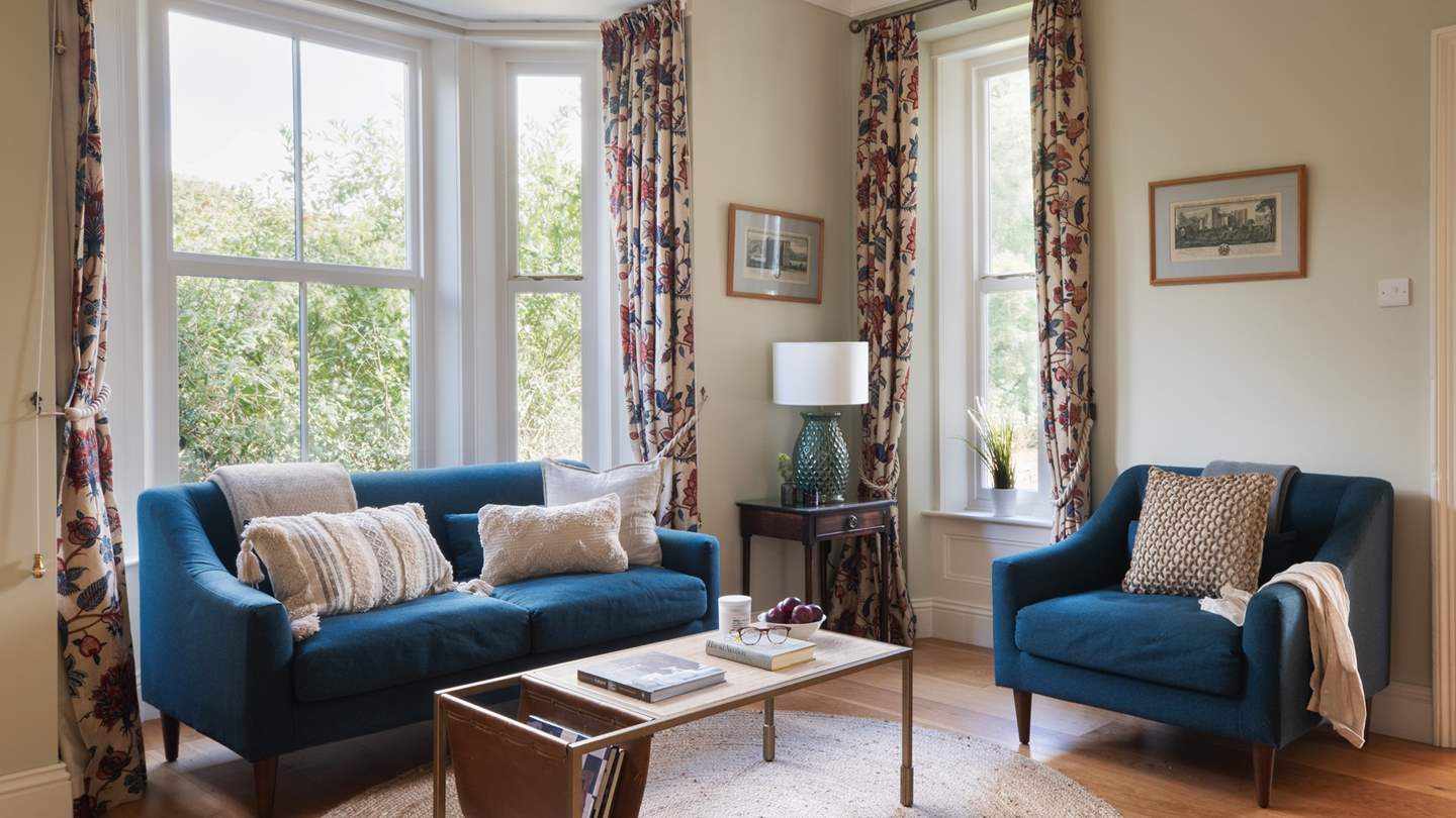 A deliciously deep blue sofa and matching chair beckon, promising cosy evenings lit by candlelight and the gently flickering glow of the fire