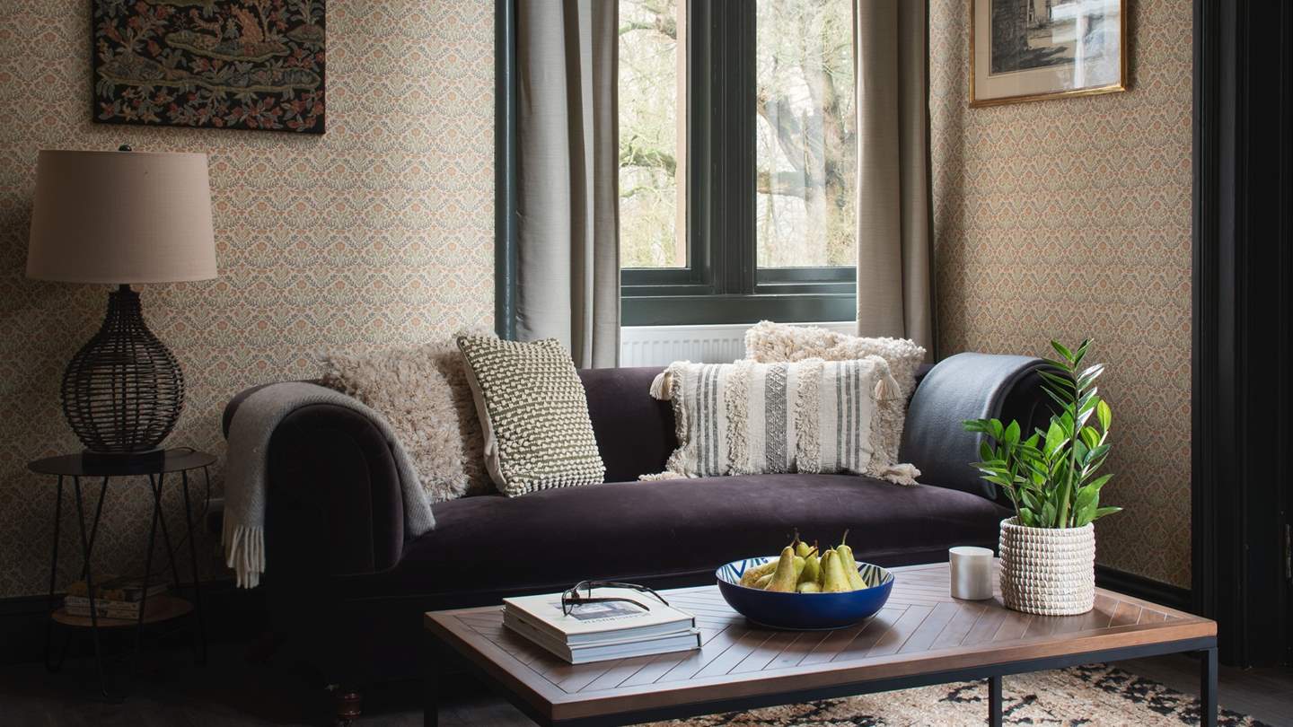 The formal sitting room is a soothing space to savour moments of calm, with a plush deep velvet sofa 