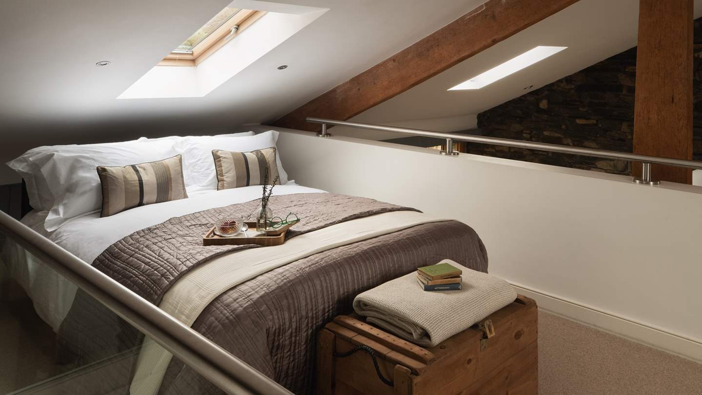 Take the floating wooden staircase to uncover the mezzanine bedroom tucked away in the eaves