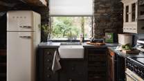 The lovely kitchen is complete with a rustic butcher block island, a custom wine rack, and a Belfast sink