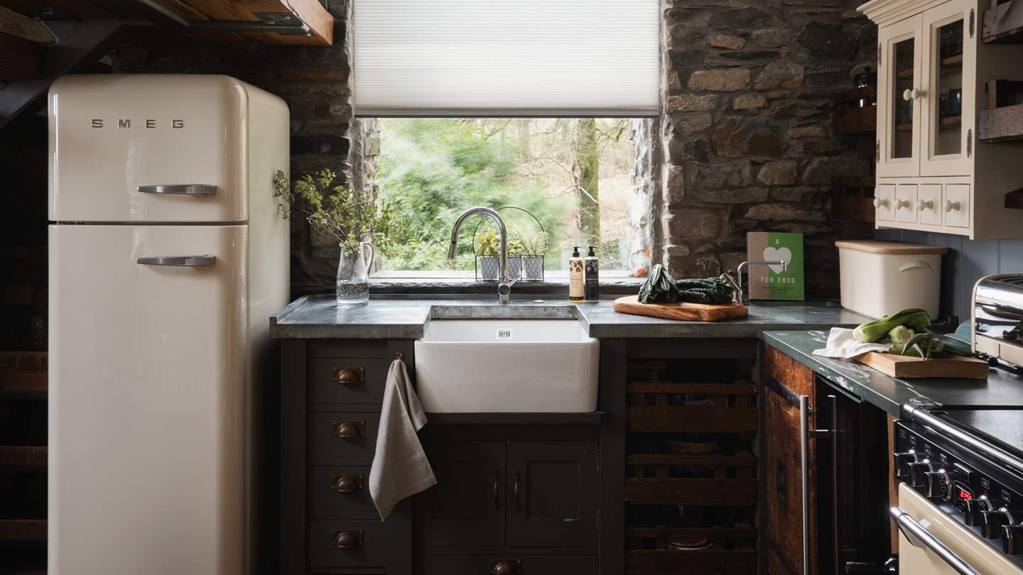 The lovely kitchen is complete with a rustic butcher block island, a custom wine rack, and a Belfast sink