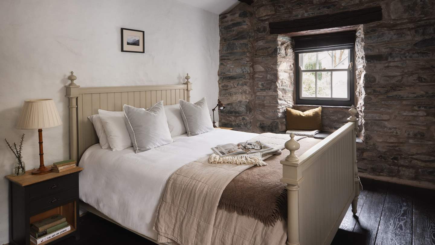Overlooking The Barn, the calming third bedroom with a king-sized bed is set amidst stunning stone walls