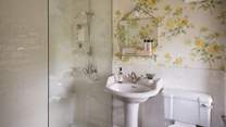 The elegant en suite has lovely yellow primrose wallpaper...