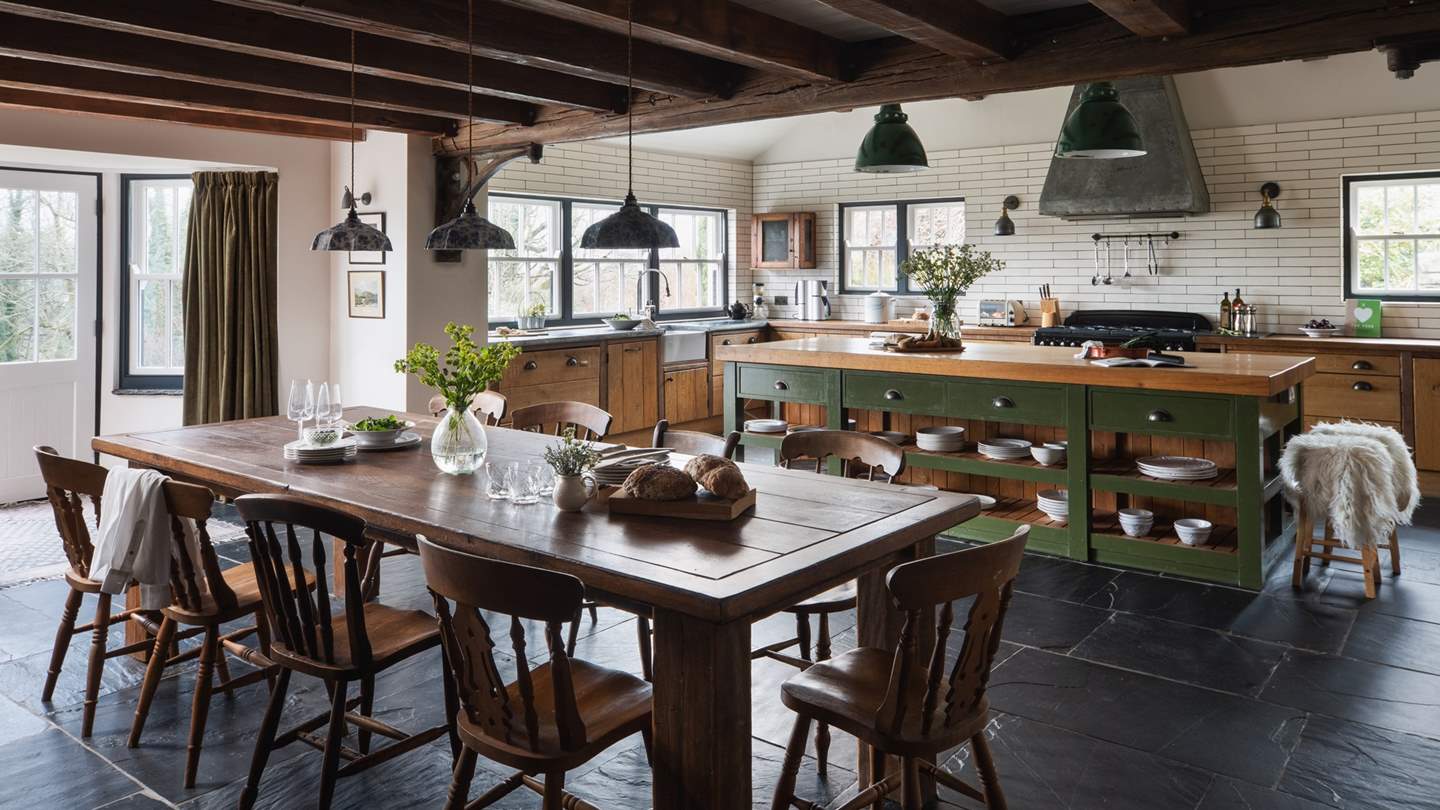 Uncover the beautiful farmhouse style open-plan kitchen and dining room, where striking slate floors and sleek, metro tiling echo the understated elegance of the interiors seen throughout Outrake Farm