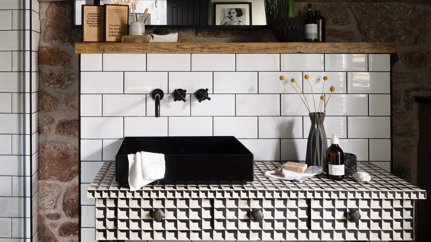 The geometric vanity and matte black sink are simply 