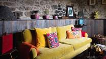 Curl up on the canary yellow sofa, bedecked with flamboyant embroidered cushions