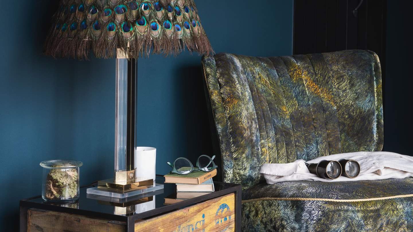 Next to the master bedroom, you’ll find a calming corner with two vintage peacock accent chairs