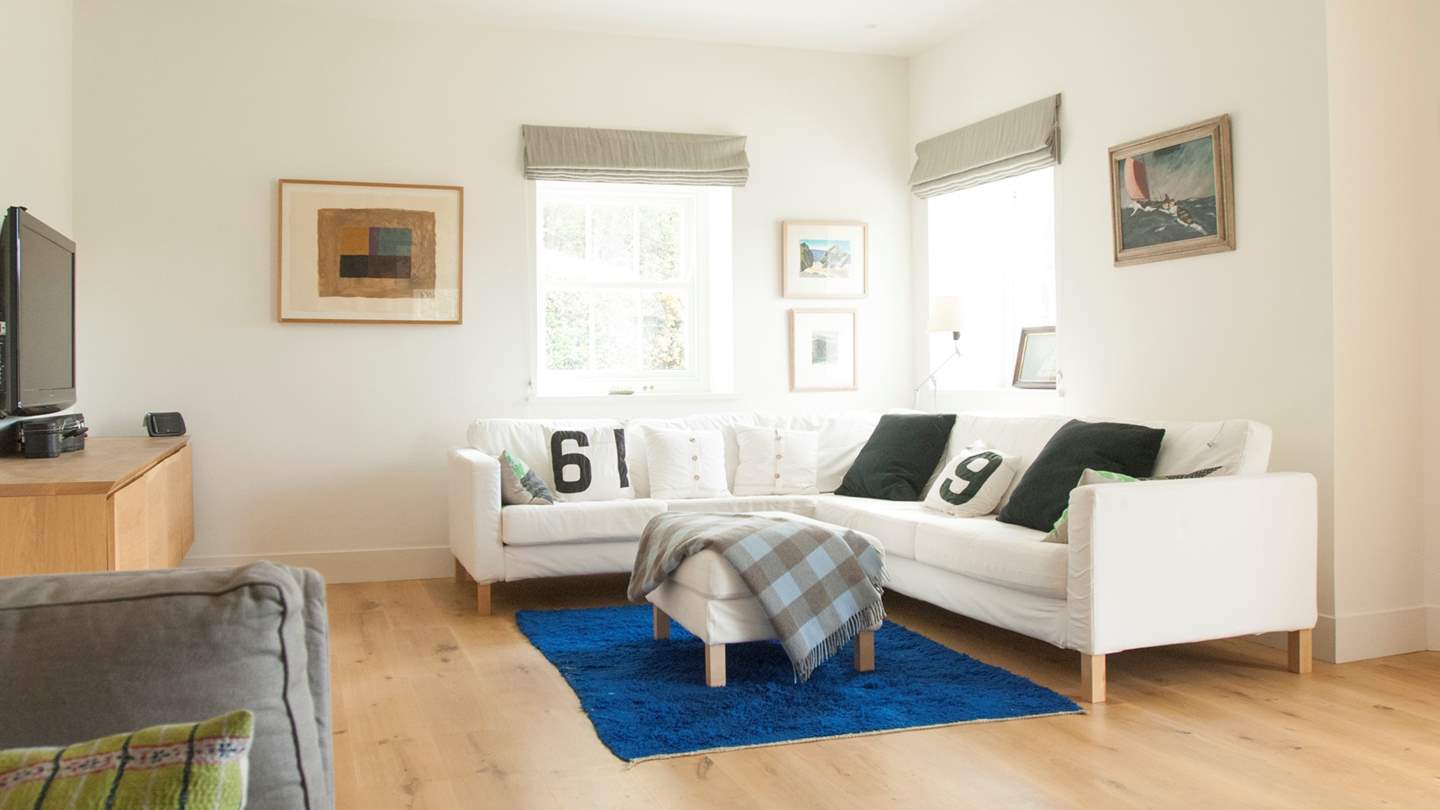 On the other side of this large room is a corner sofa with large TV